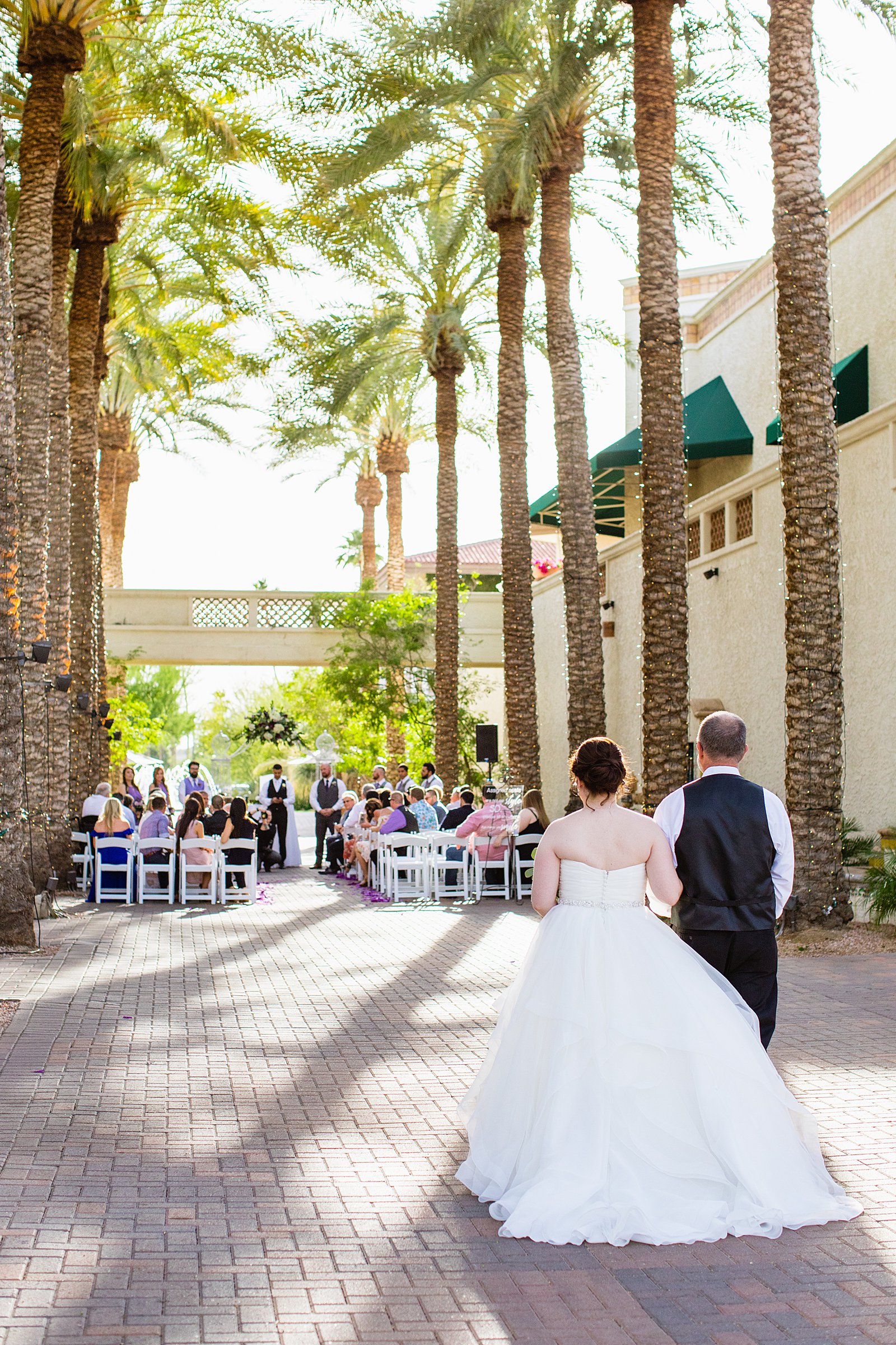 Bride walking down aisle during Arizona Grand Resort wedding ceremony by Phoenix wedding photographer PMA Photography.