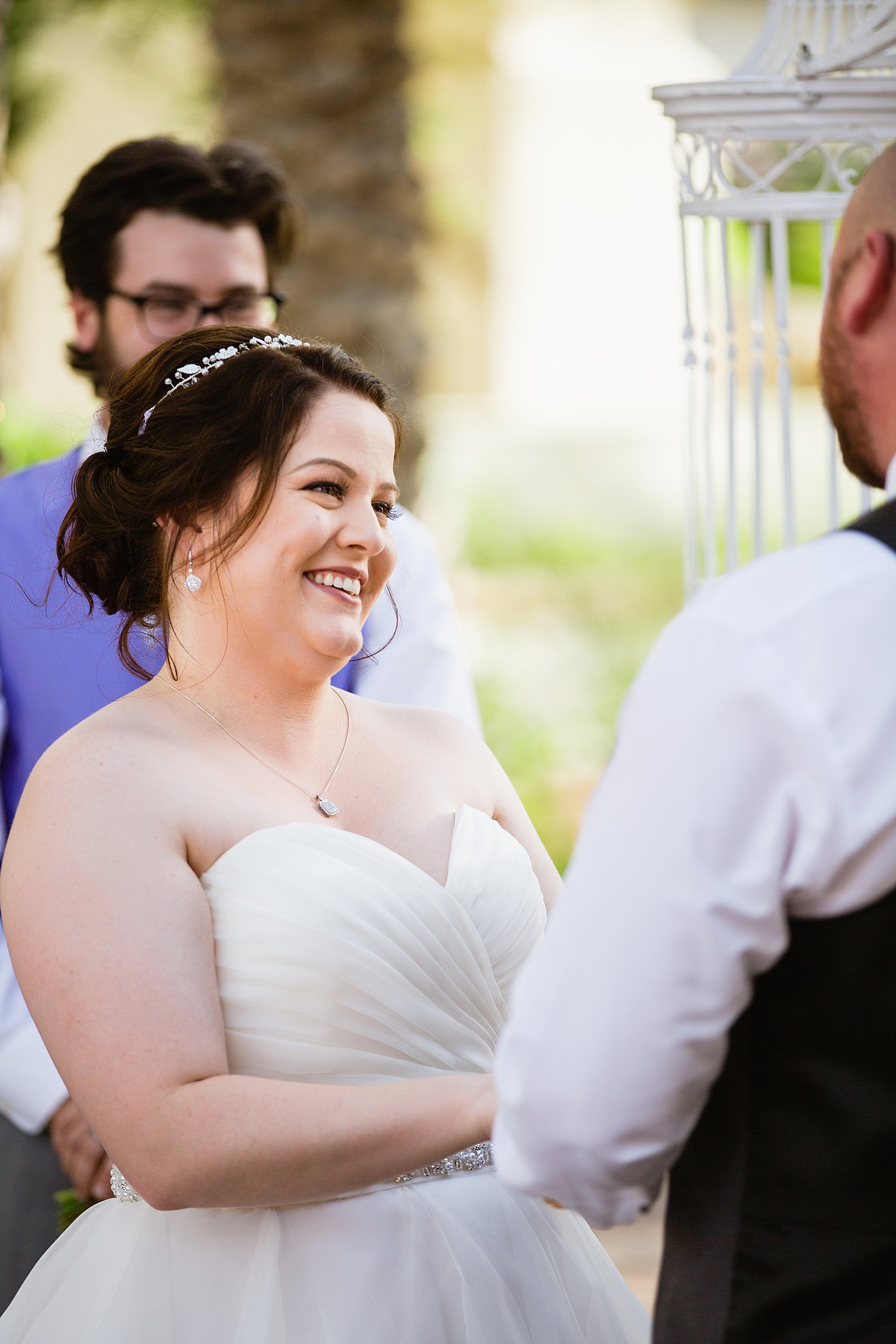 Bride looking at her groom during their wedding ceremony at Arizona Grand Resort by Phoenix wedding photographer PMA Photography.