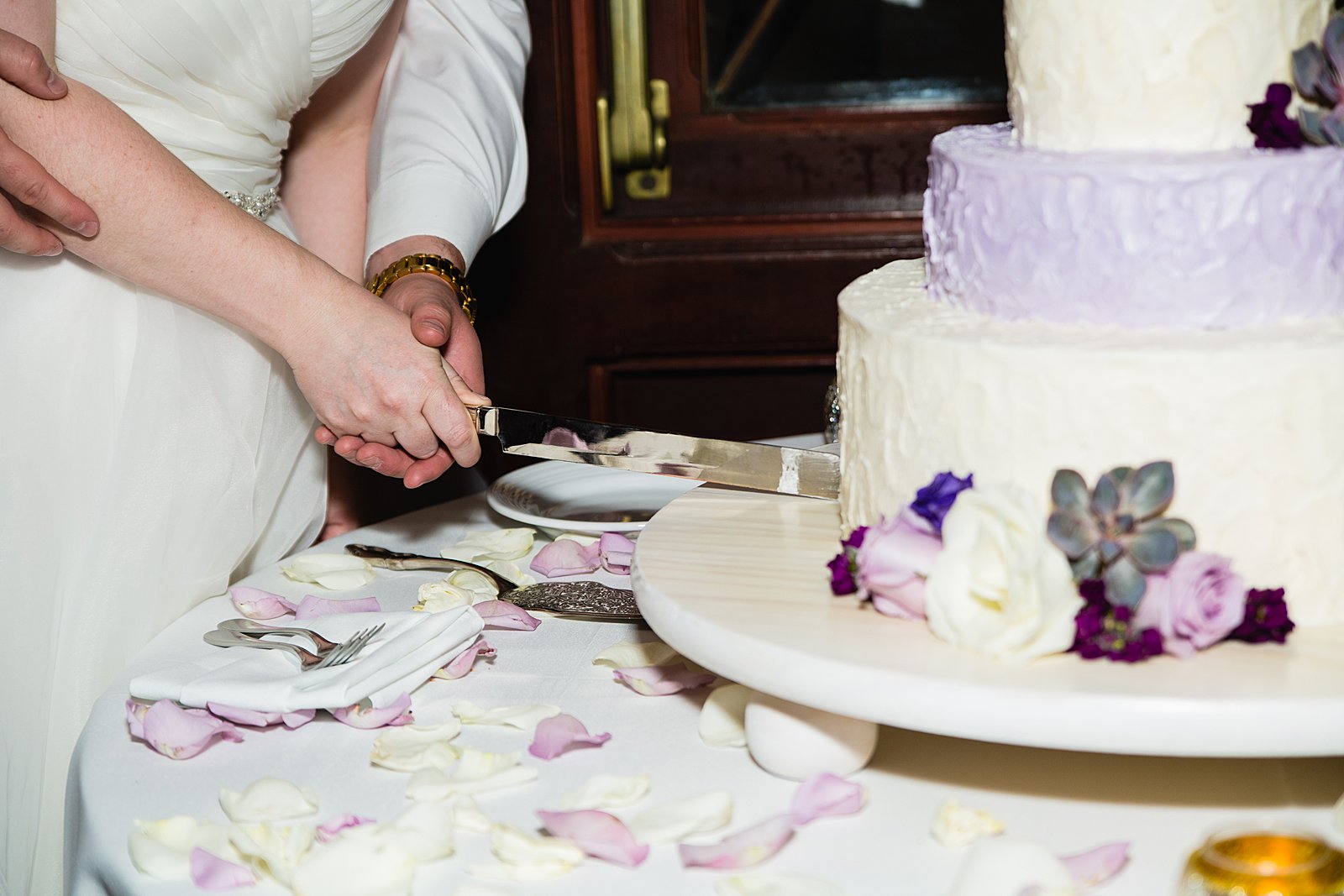 Bride and Groom cutting their wedding cake at their Arizona Grand Resort wedding reception by Arizona wedding photographer PMA Photography.