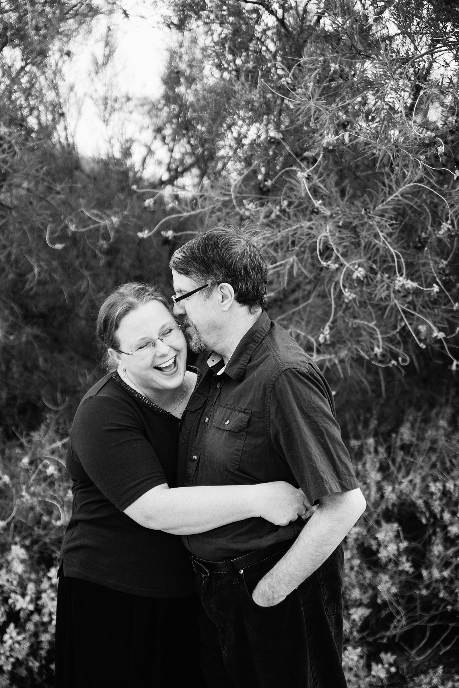Couple laugh together during their Veterans Oasis Park engagement session by Gilbert engagement photographer PMA Photography.