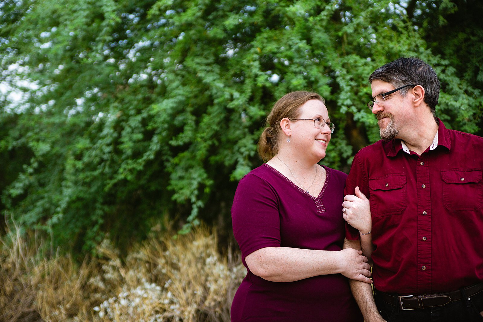 Couple look at each other during their Gilbert engagement session by Arizona wedding photographer PMA Photography.