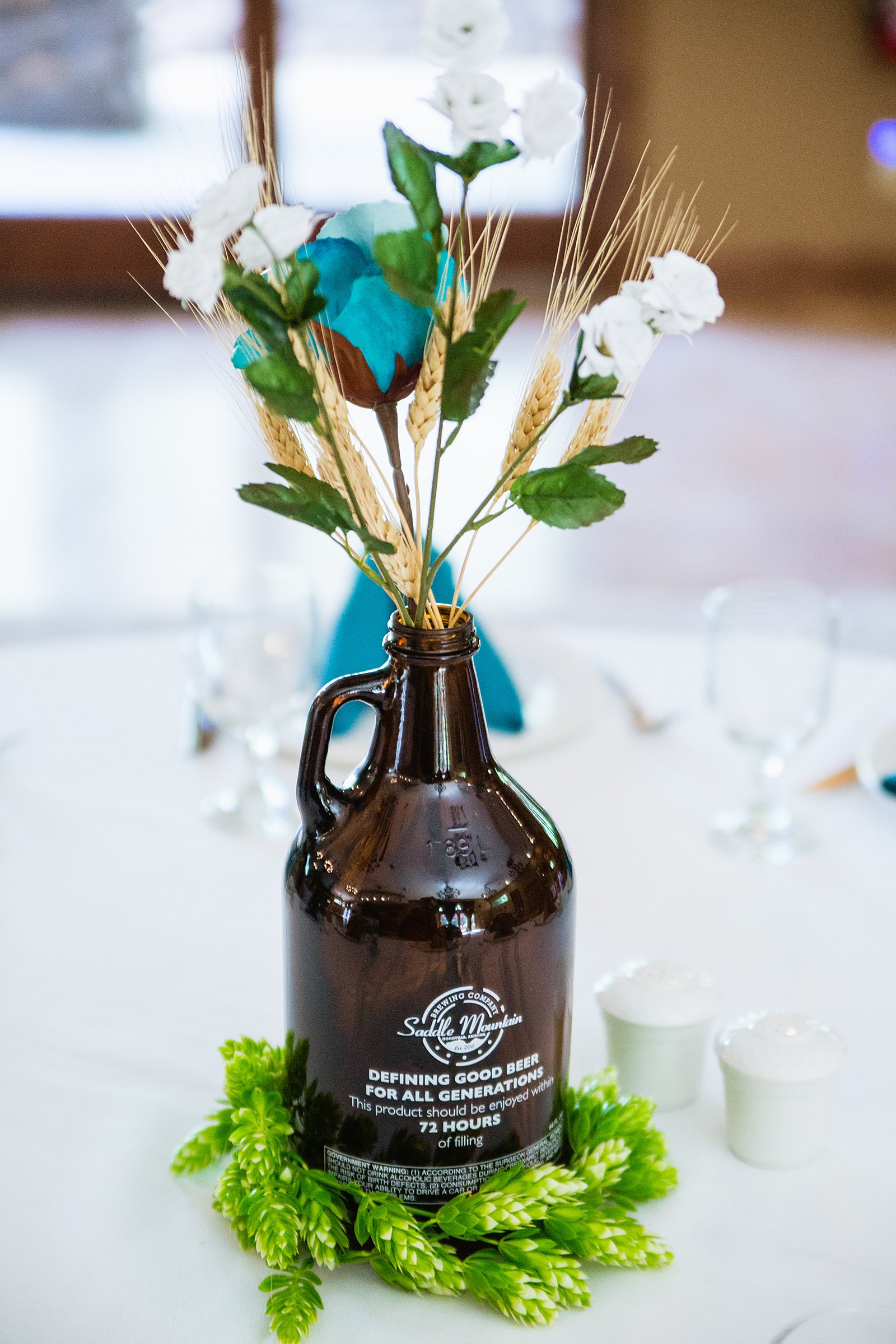 Brewery glass jug centerpieces at The Windmill House wedding reception by Chino Valley wedding photographer PMA Photography.
