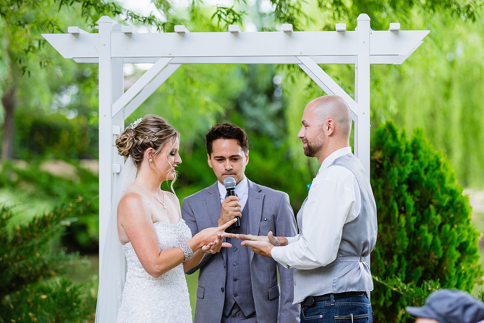 Bride and Groom playing rock paper scissors during their wedding ceremony by Phoenix wedding photographers PMA Photography.
