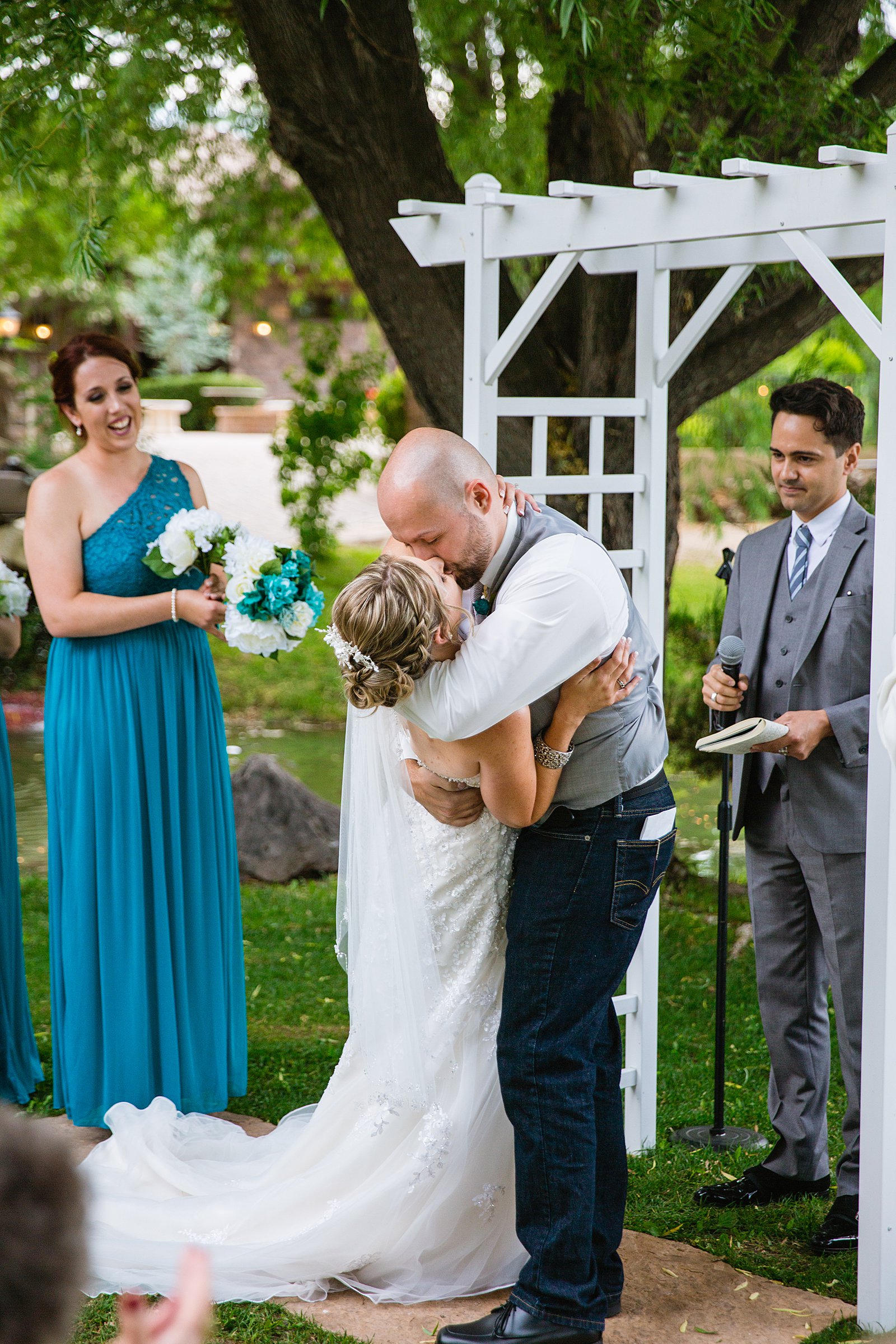 Bride and Groom share their first kiss during their wedding ceremony at The Windmill House by Arizona wedding photographer PMA Photography.
