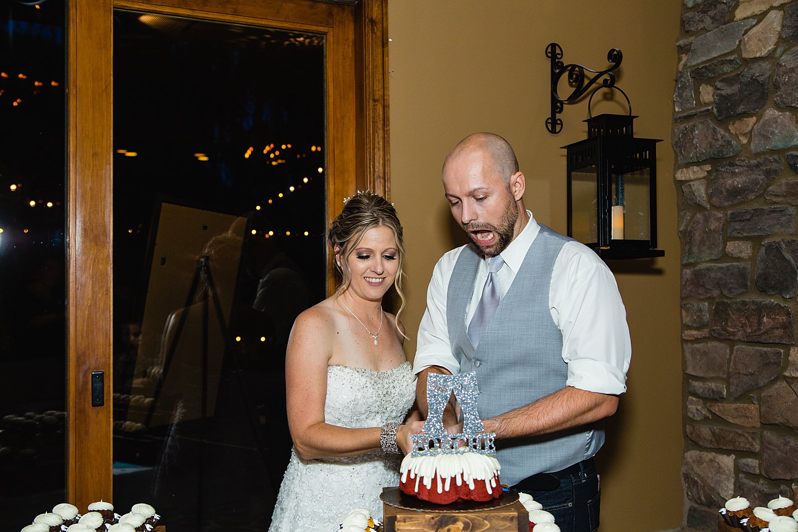 Bride and Groom cutting their wedding cake at their The Windmill House wedding reception by Arizona wedding photographer PMA Photography.