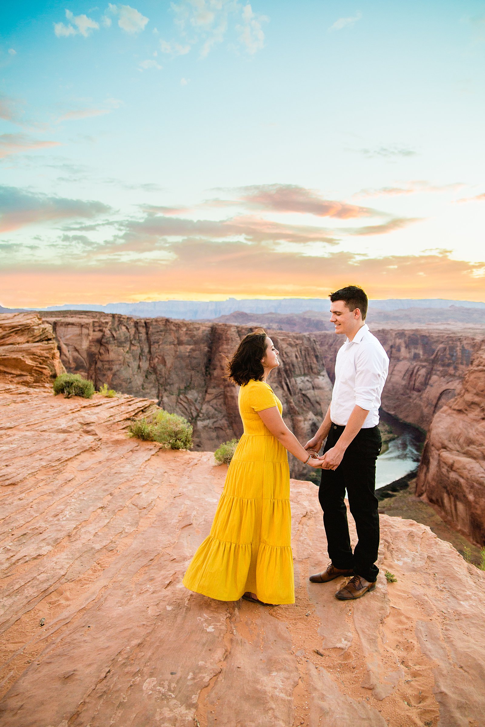 Couple look at each other during their Horshoe Bend engagement session by Page wedding photographer PMA Photography.