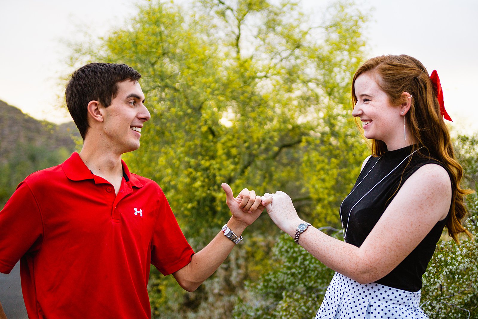 Couple share a pinkie promise at their Phoenix anniversary session by Arizona engagement photographer PMA Photography.