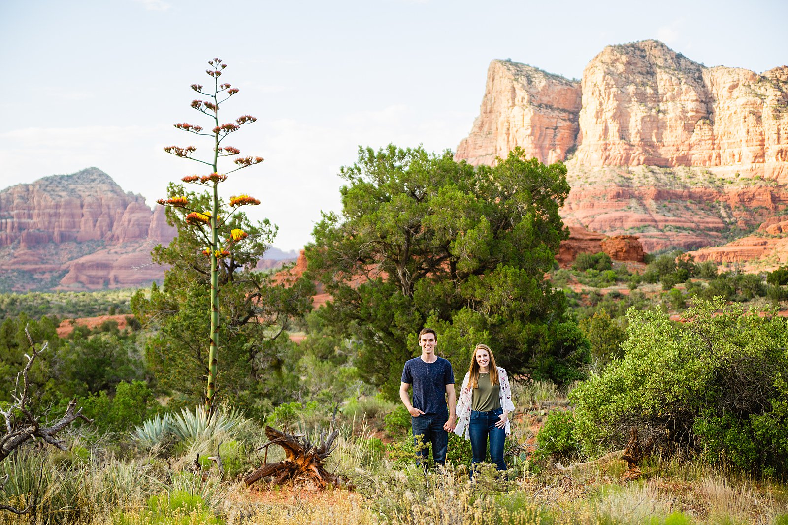 Adventurous couple pose for their Bell Rock engagement session by Sedona wedding photographer PMA Photography.