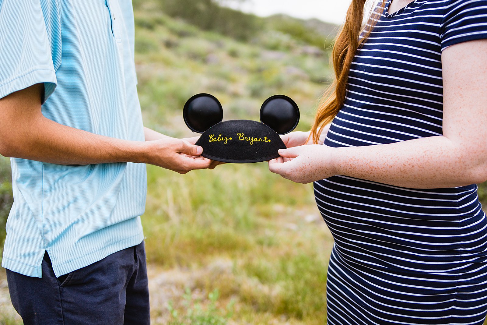 Couple hold a custom Baby Disney Mouse Ears for their maternity session by PMA Photography.