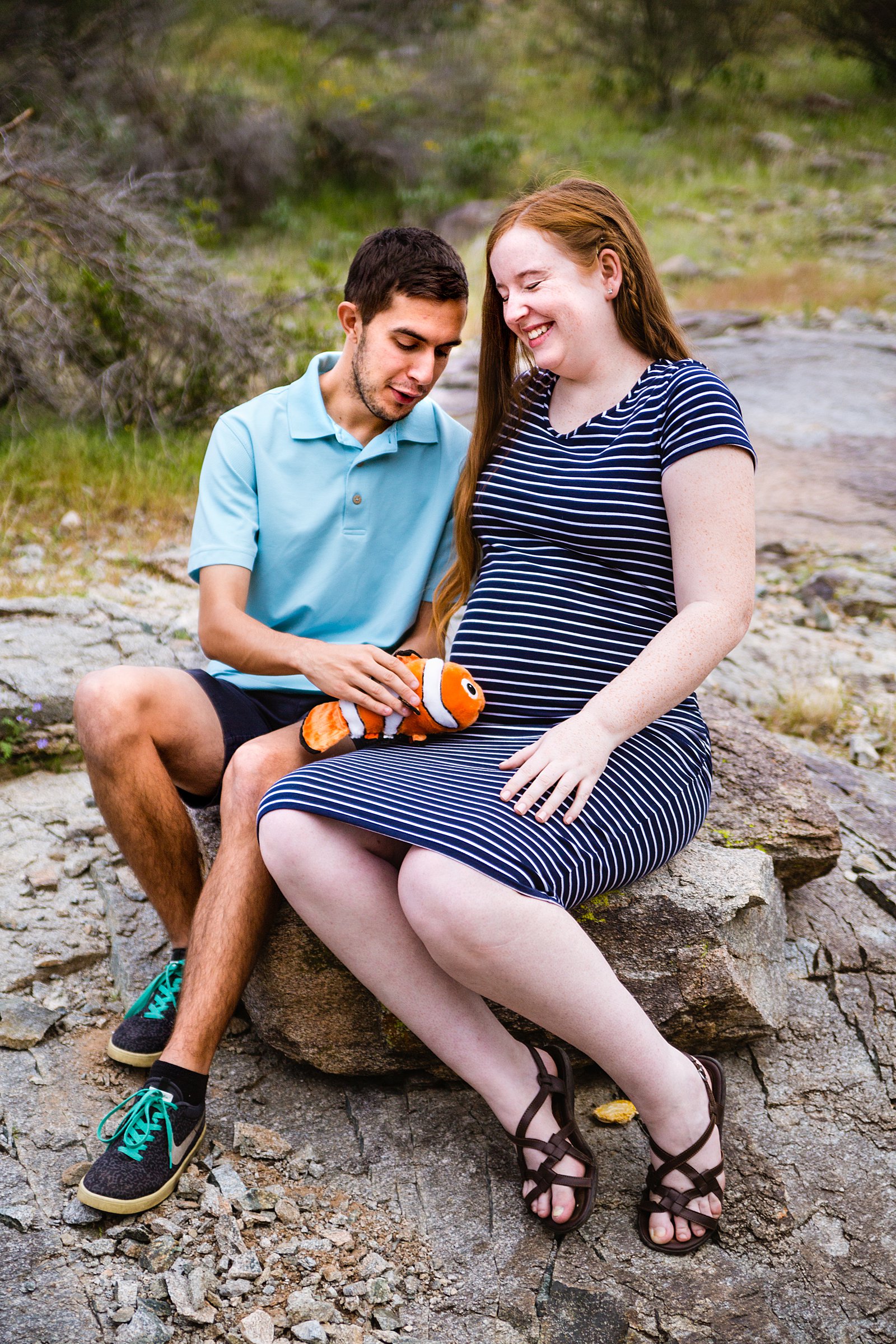 Couple laugh together during their Phoenix maternity session by Arizona engagement photographer PMA Photography.