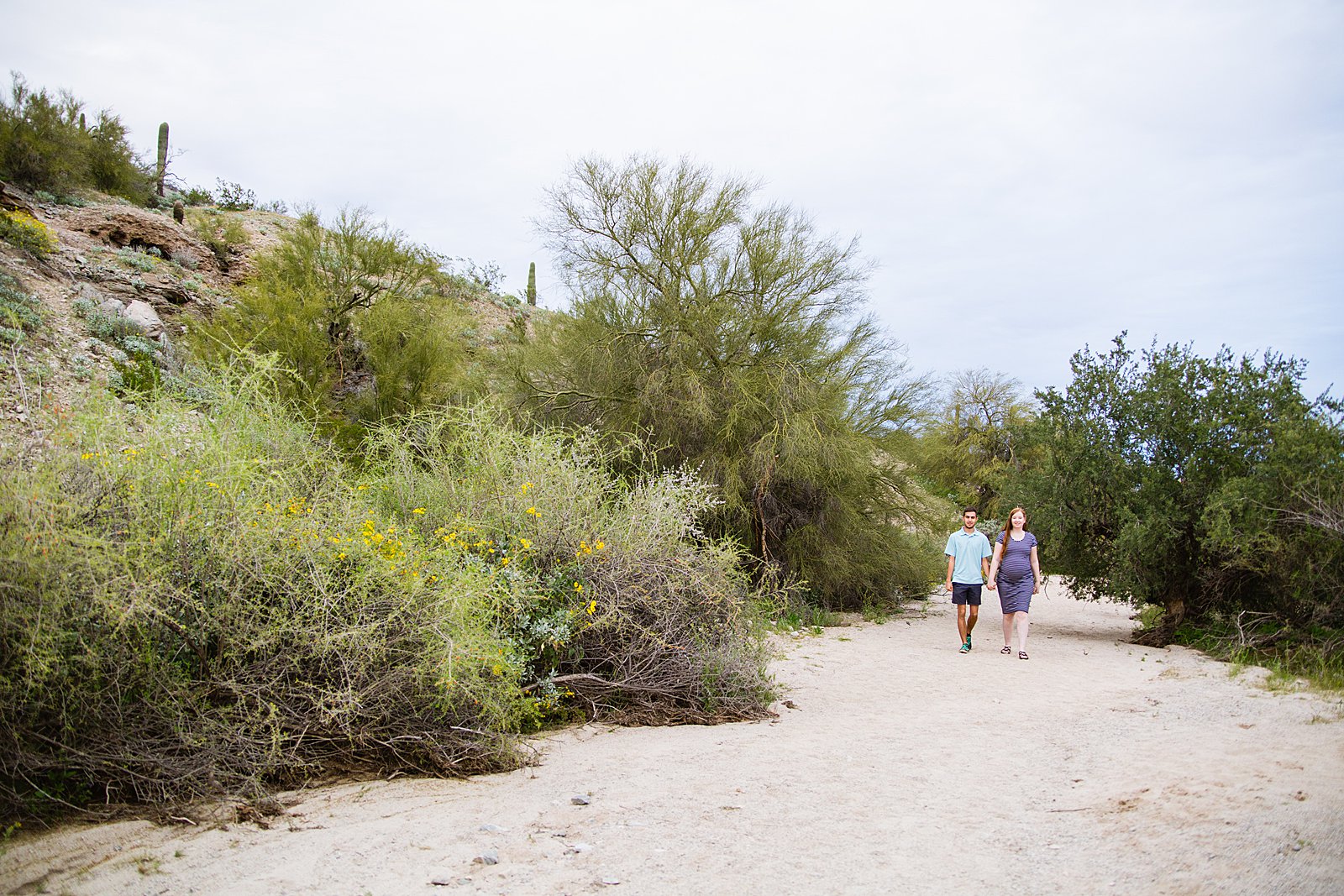 Couple walking together during their Pima Canyon maternity session by Phoenix engagement photographer PMA Photography.