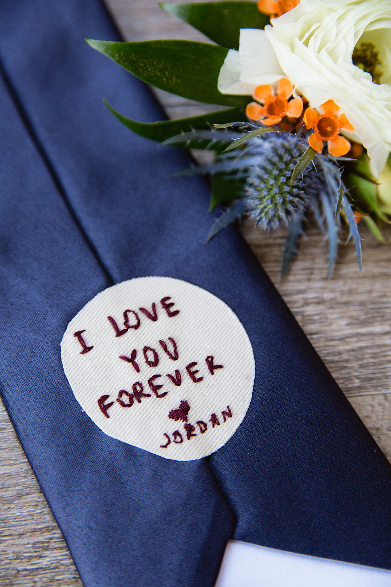 Custom message in groom's tie from the bride by Arizona wedding photographer PMA Photography.