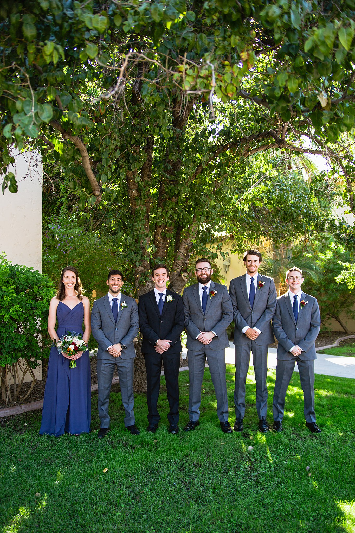 Groom and mixed gender bridal party together at a Secret Garden Events wedding by Arizona wedding photographer PMA Photography.