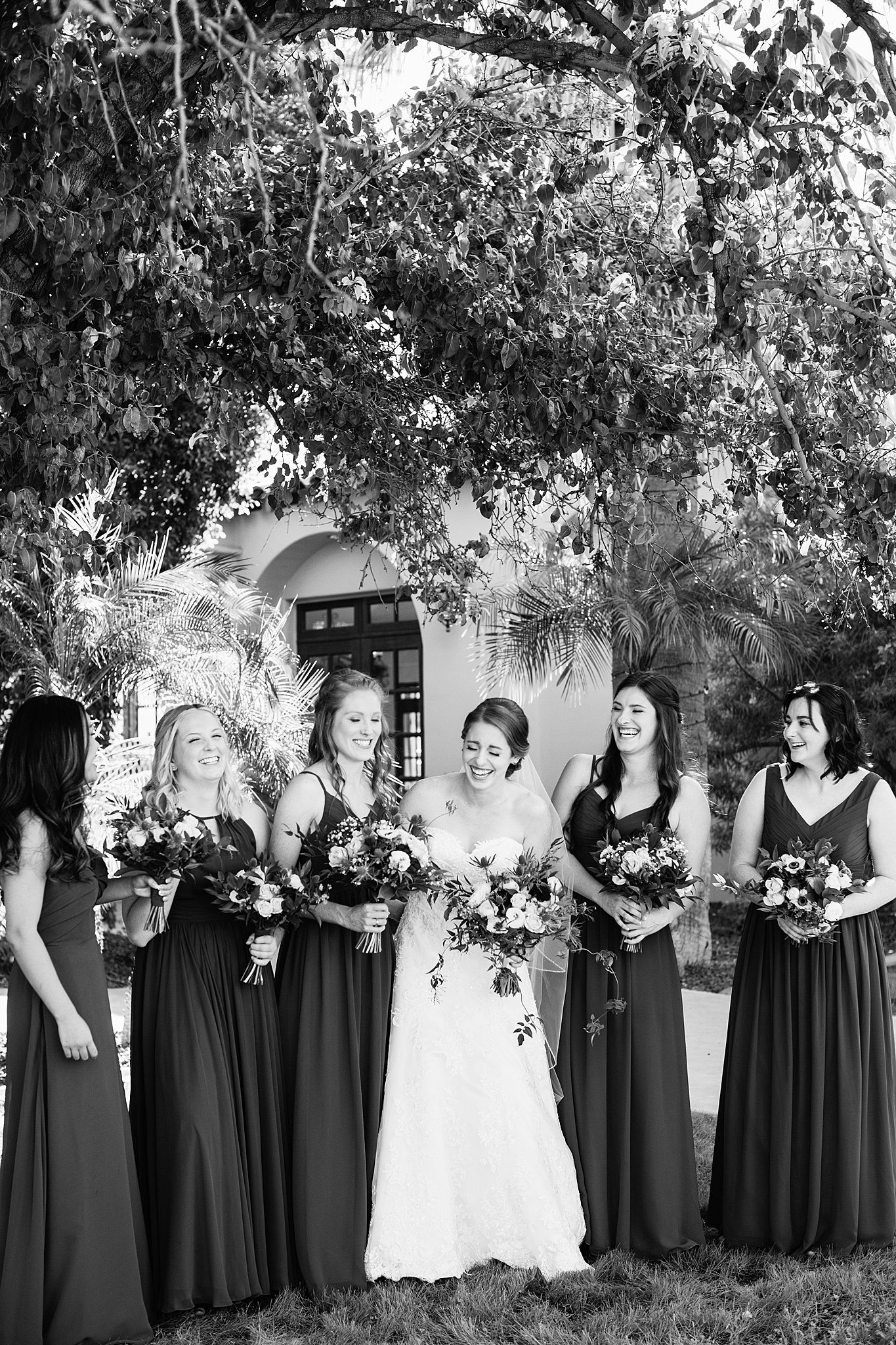 Bride and bridesmaids laughing together at Secret Garden Events wedding by Phoenix wedding photographer PMA Photography.