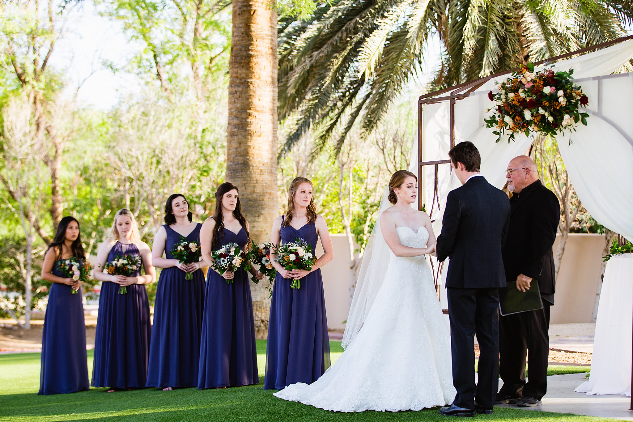 Bride looking at her groom during their wedding ceremony at Secret Garden Events by Phoenix wedding photographer PMA Photography.