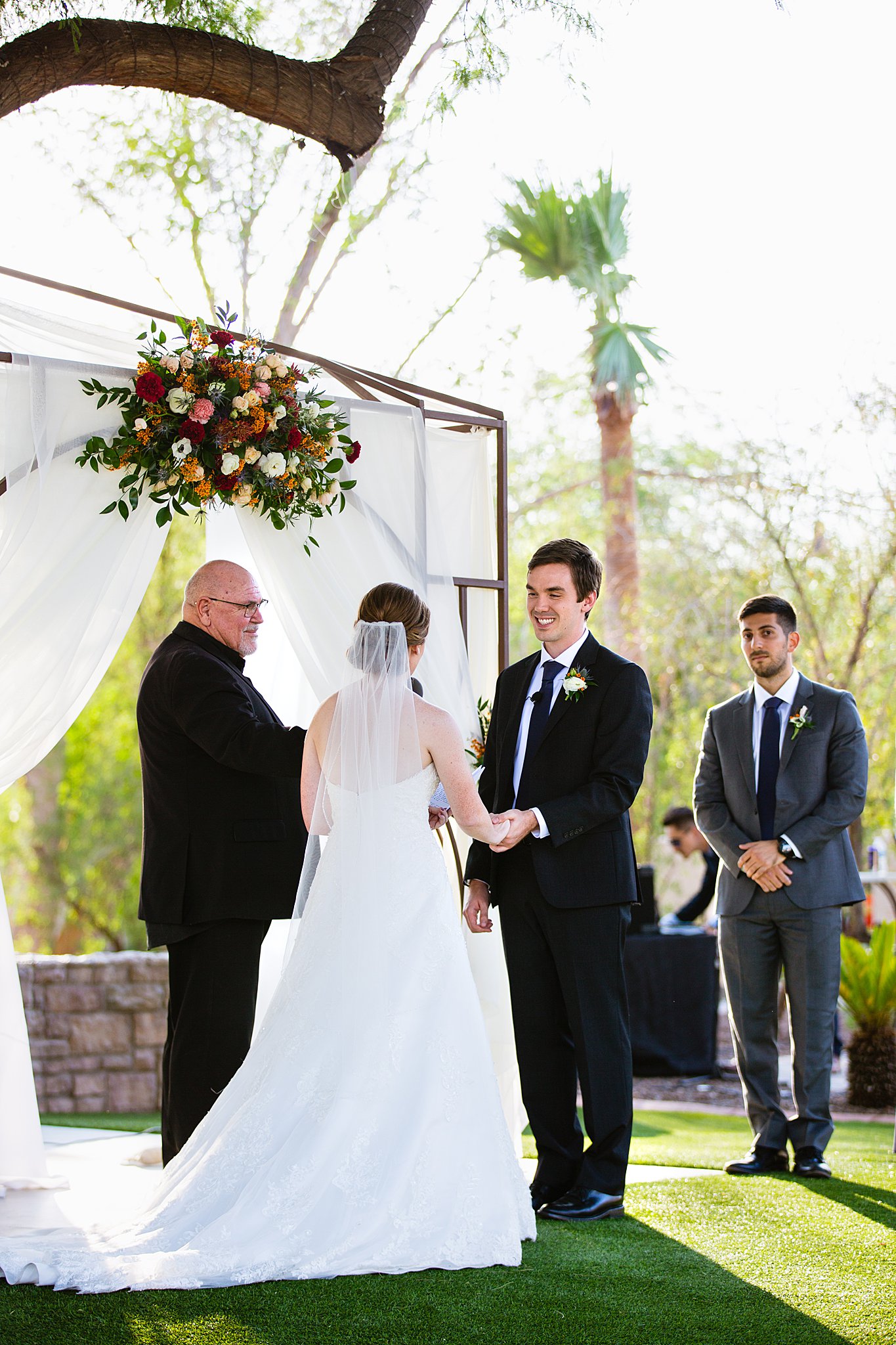 Groom looking at his bride during their wedding ceremony at Secret Garden Events by Phoenix wedding photographer PMA Photography.