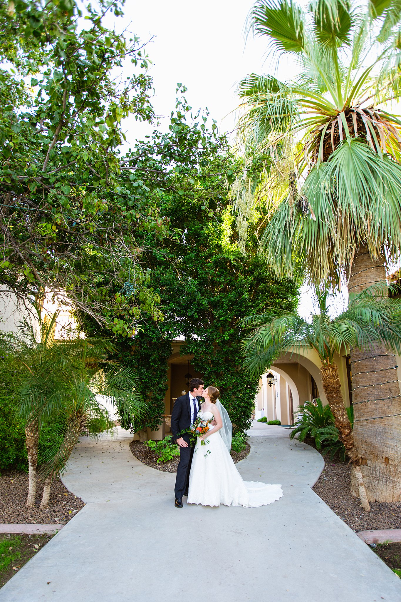 Bride and Groom share a kiss during their Secret Garden Events wedding by Arizona wedding photographer PMA Photography.