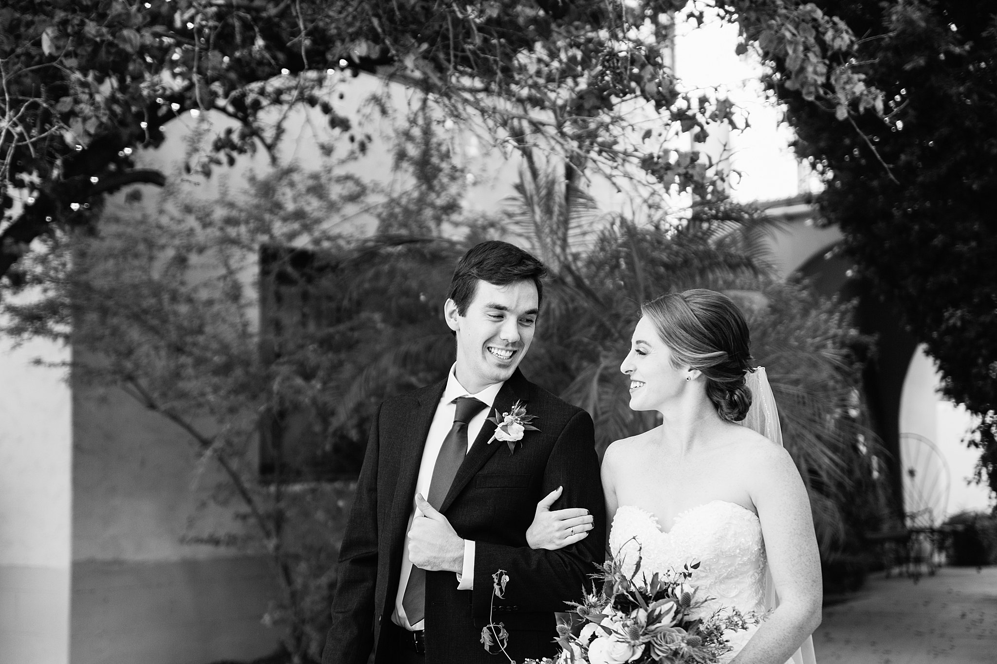 Bride and Groom walking together during their Secret Garden Events wedding by Arizona wedding photographer PMA Photography.