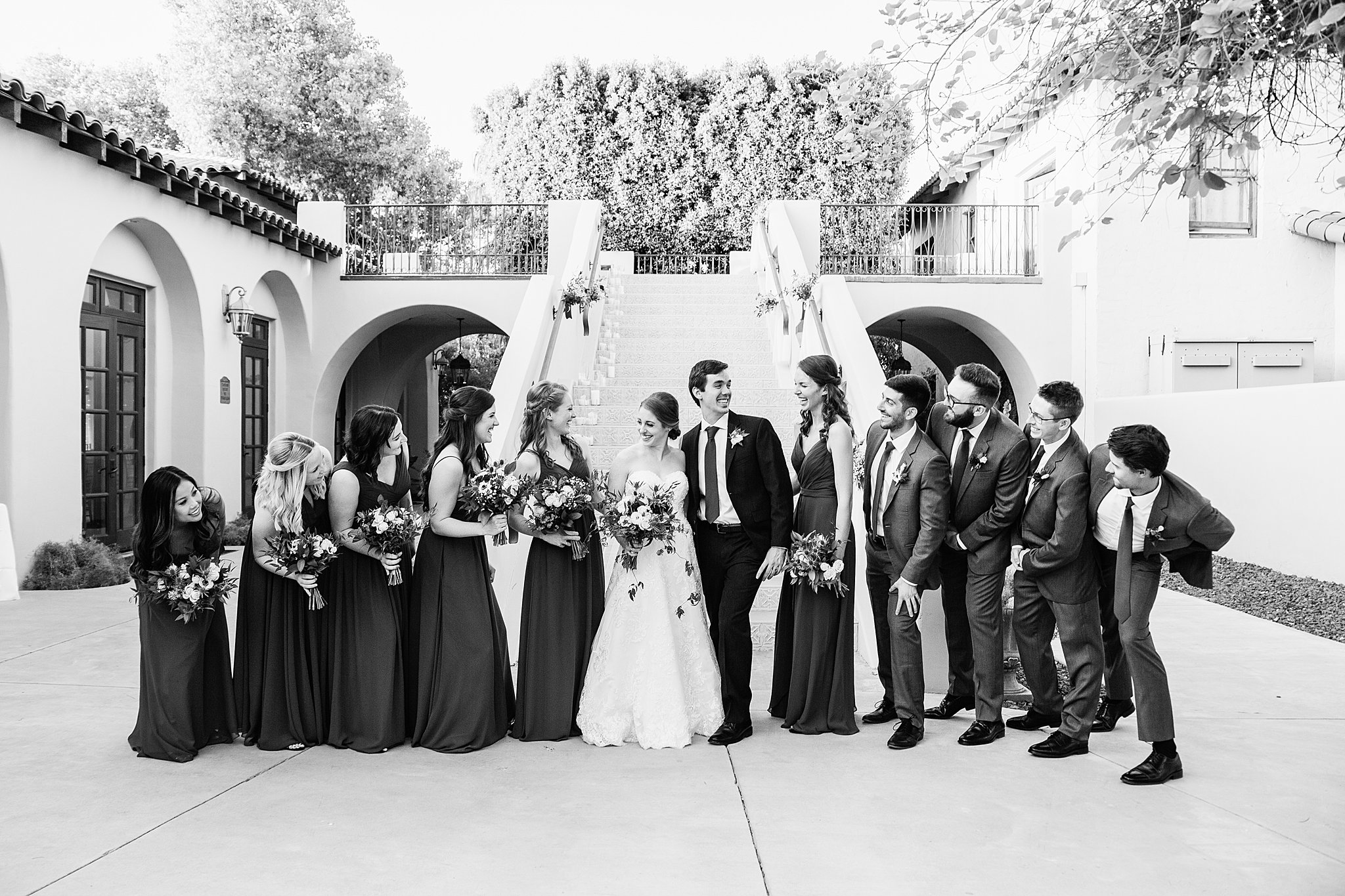 Mixed gender bridal party laughing together at Secret Garden Events wedding by Phoenix wedding photographer PMA Photography.