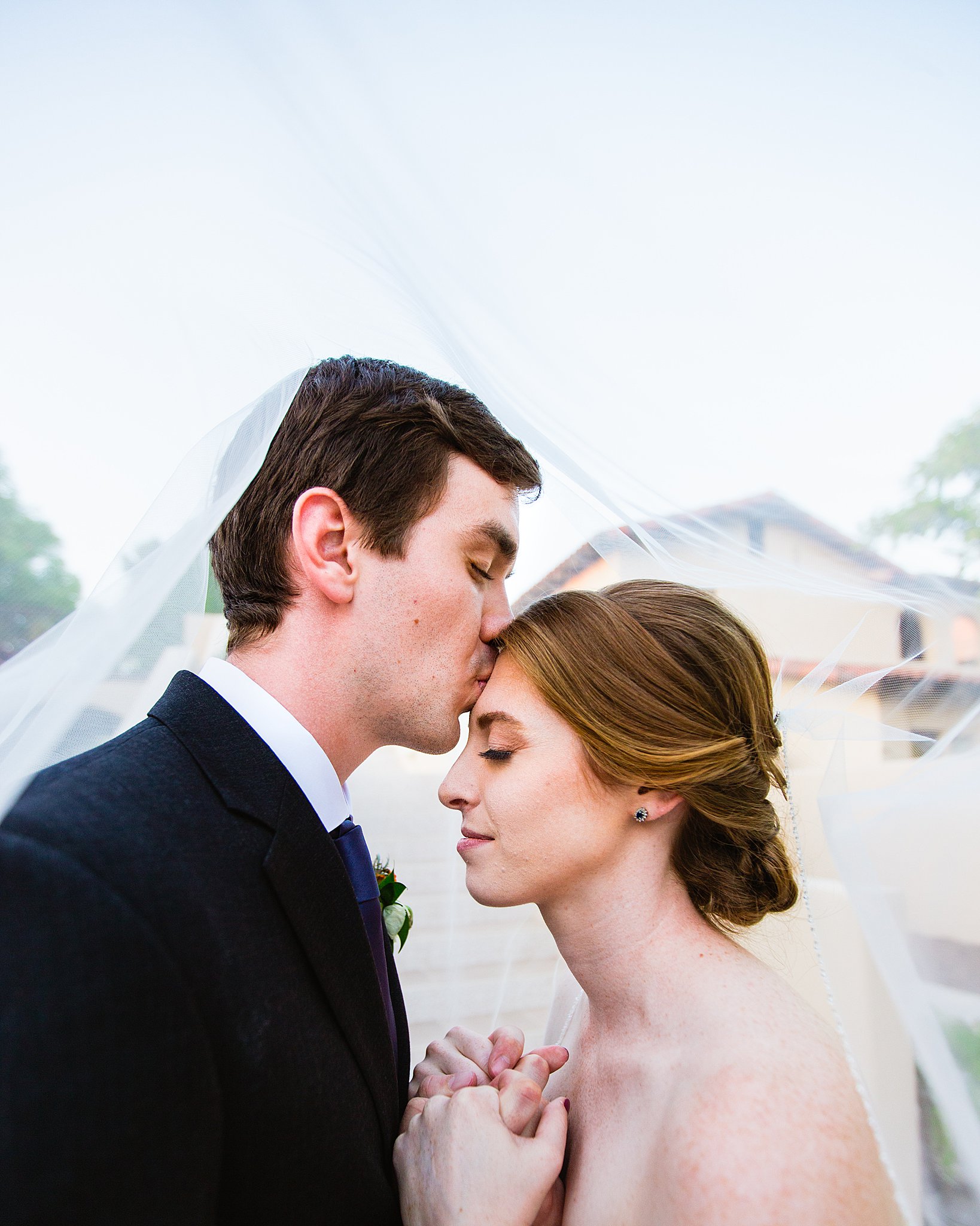 Bride and Groom share a kiss during their Secret Garden Events wedding by Phoenix wedding photographer PMA Photography.