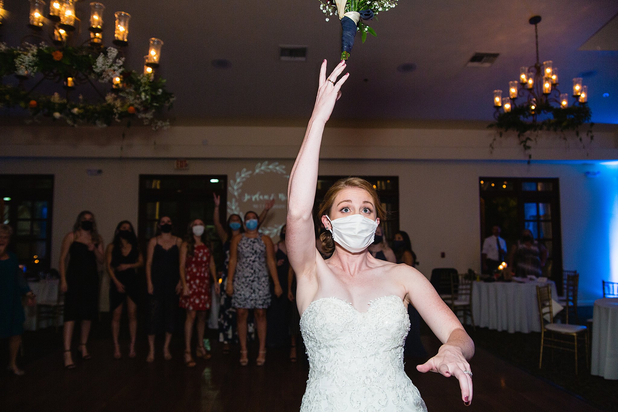 Bouquet toss at Secret Garden Events wedding reception by Phoenix wedding photographer PMA Photography.