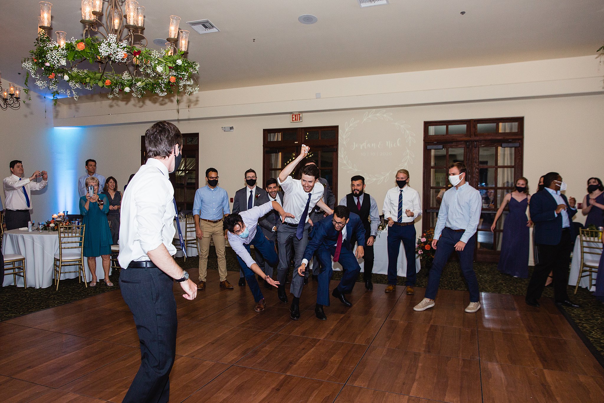 Garter toss at Secret Garden Events wedding reception by Phoenix wedding photographer PMA Photography.