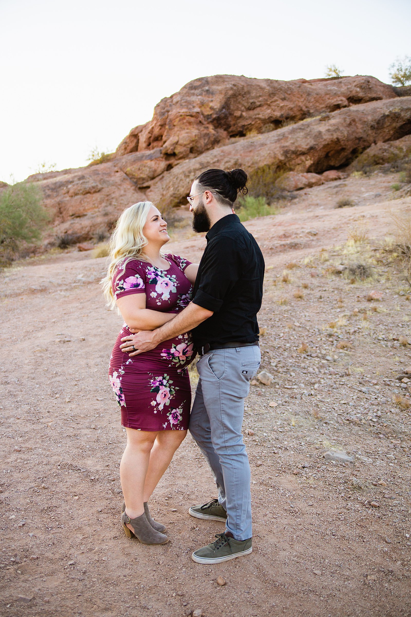 Couple look at each other during their Papago Park maternity session by Phoenix wedding photographer PMA Photography.