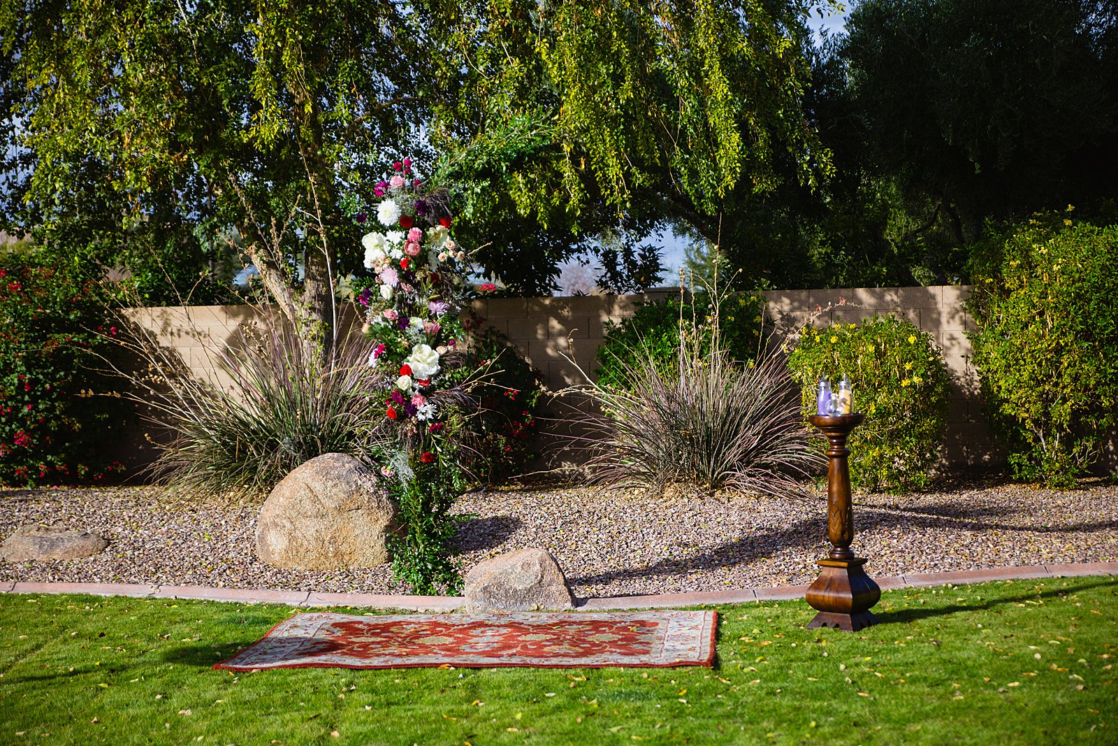Lush and colorful floral wedding arch for a backyard wedding by Phoenix wedding photographer PMA Photography.