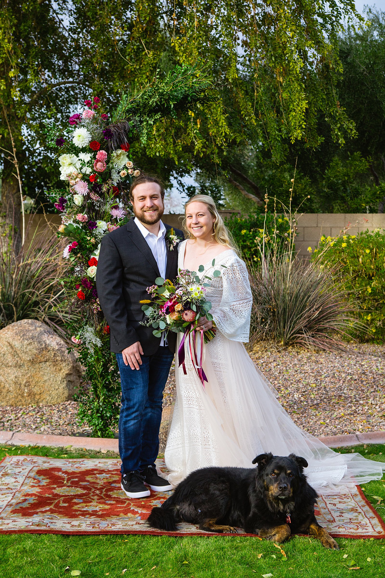 Bride and Groom pose with their dog during their Backyard wedding by Arizona wedding photographer PMA Photography.