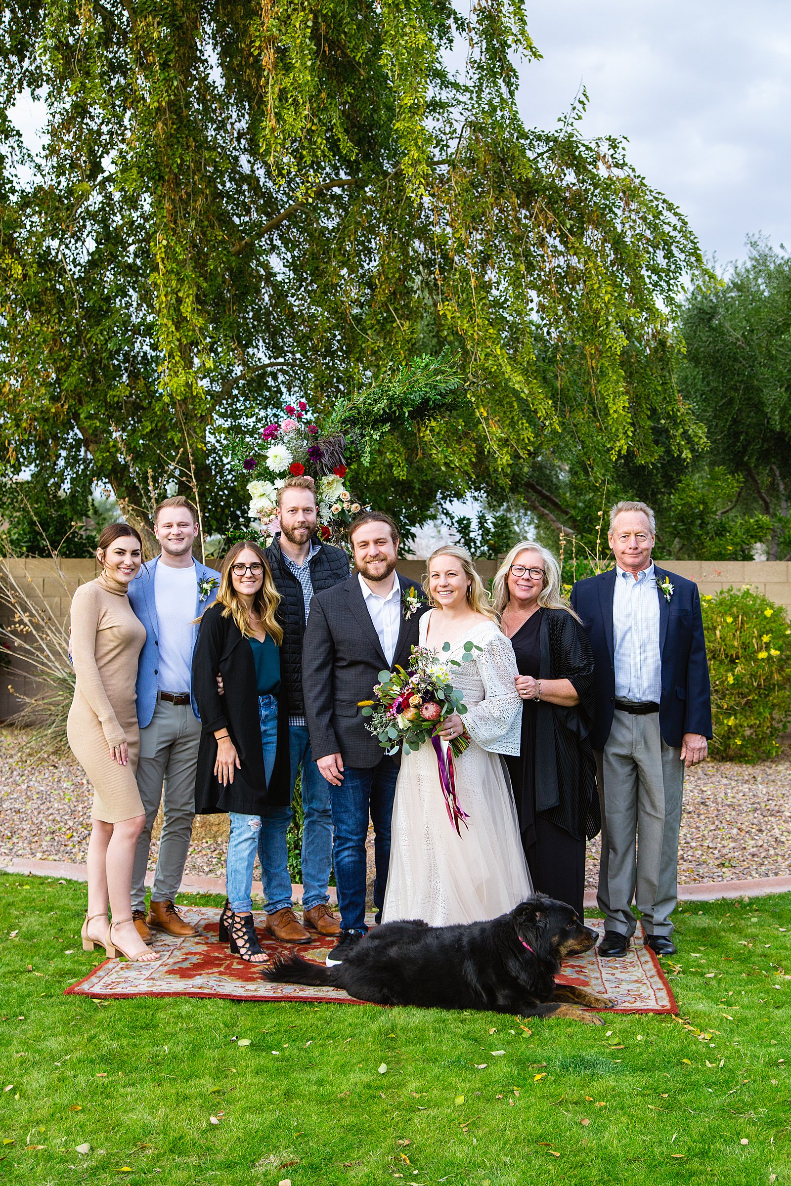 Bride and Groom pose with their family during their Backyard wedding by Arizona wedding photographer PMA Photography.