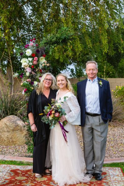 Bride and Groom pose with their family during their Backyard wedding by Arizona wedding photographer PMA Photography.