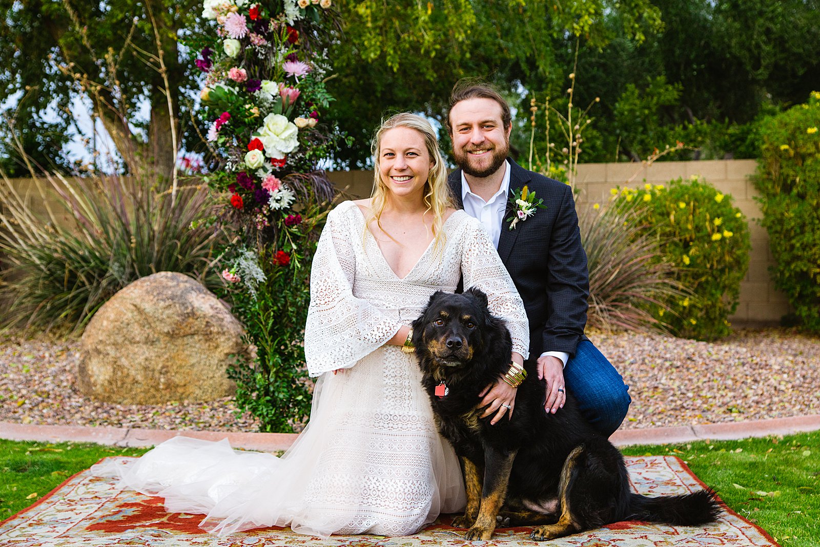 Bride and groom pose with their dog for their Backyard wedding by Phoenix wedding photographer PMA Photography.