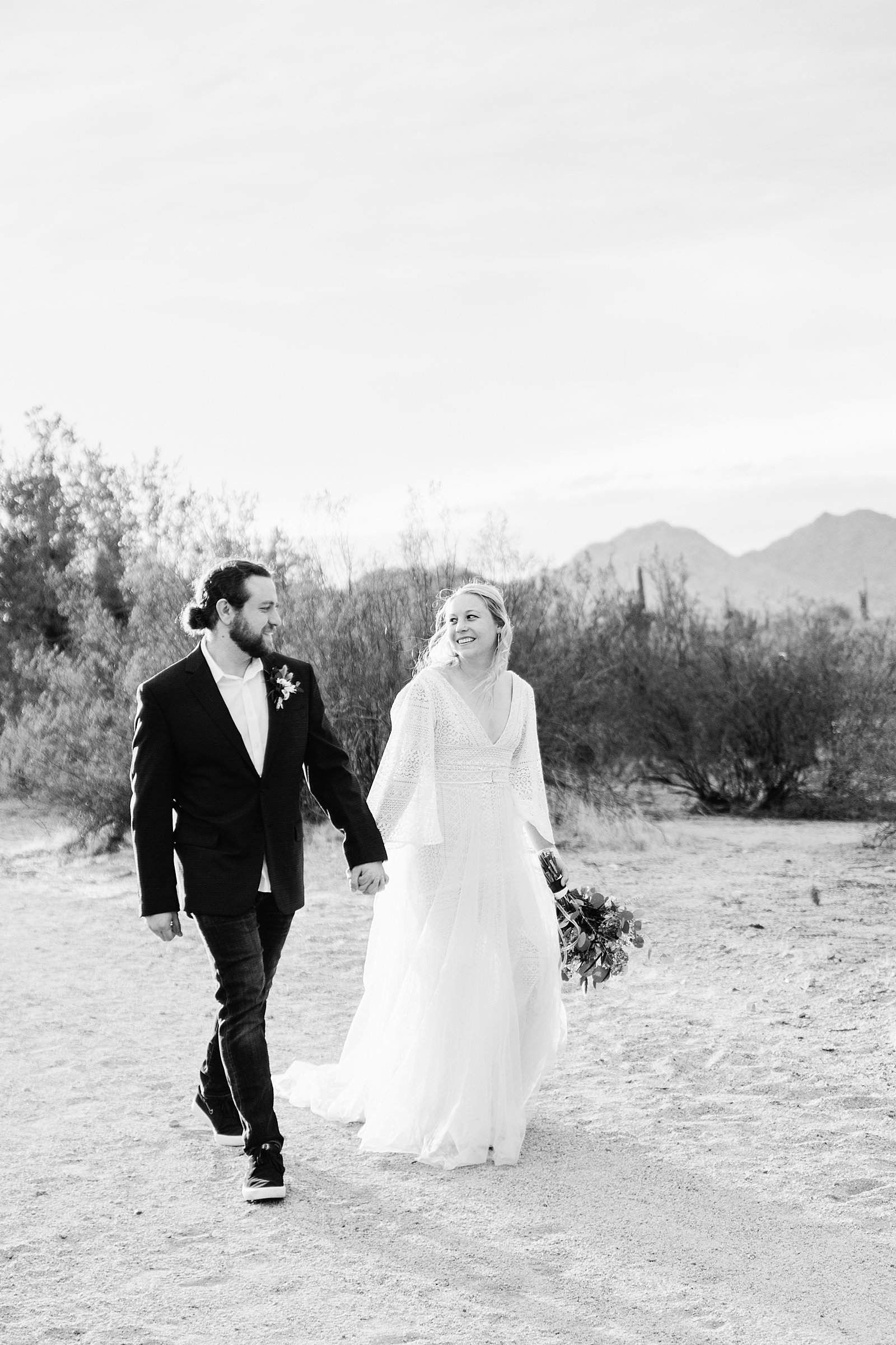 Bride and Groom walking together during their San Tan Regional Park wedding by Arizona wedding photographer PMA Photography.