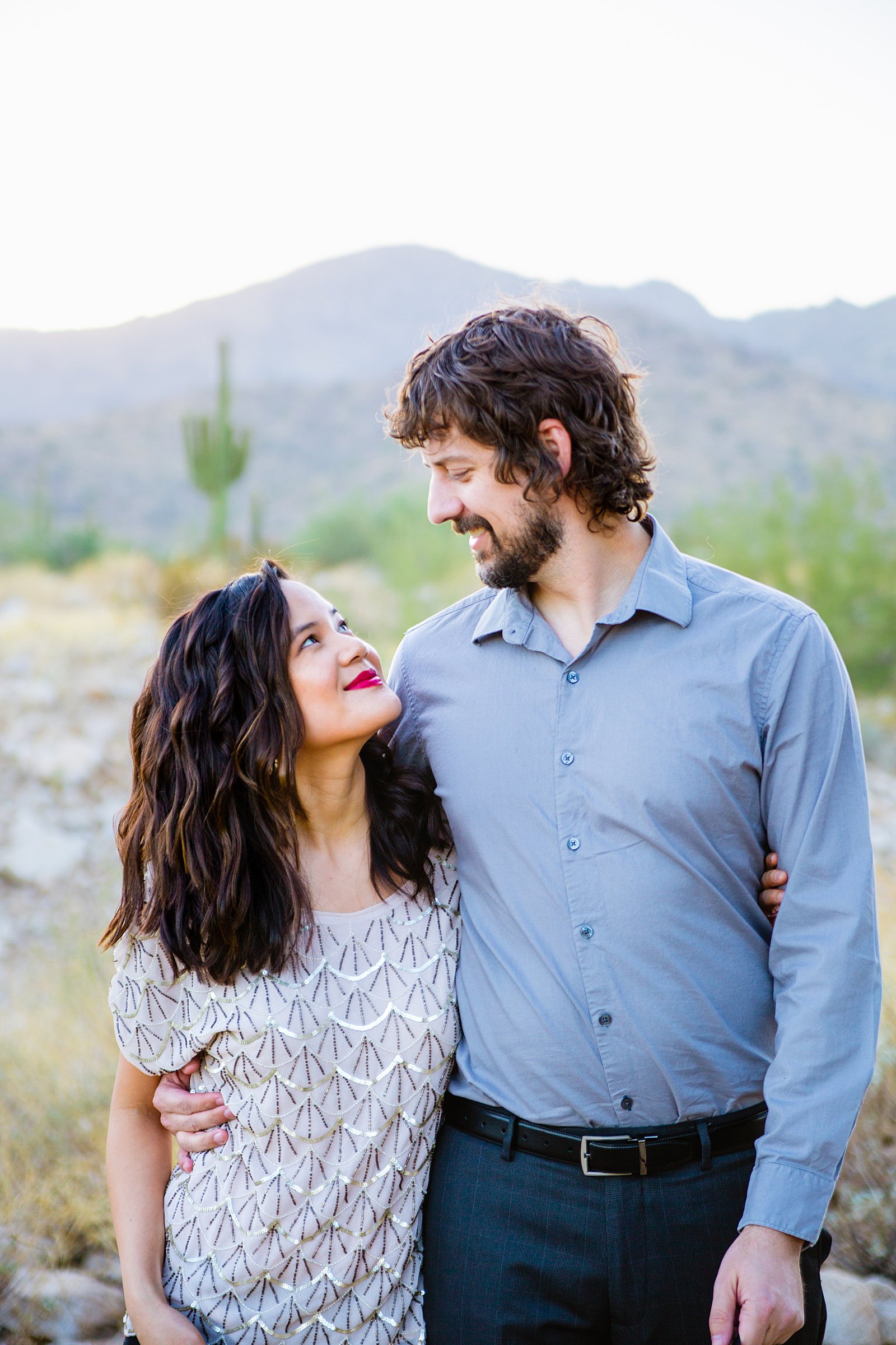 Couple looks at each other during their White Tanks family session by Phoenix family photographer PMA Photography.