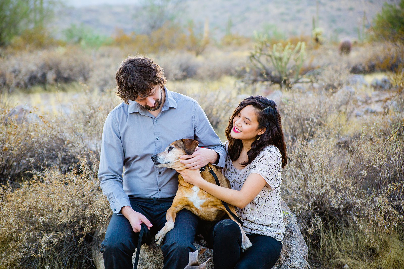Couple poses together with their dogs during their Phoenix family session by Arizona wedding photographer PMA Photography.