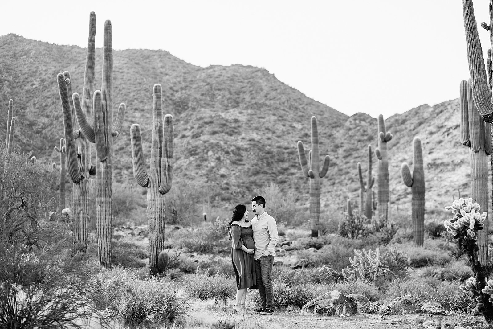 Couple look at each other during their Phoenix maternity session by Arizona wedding photographer PMA Photography.