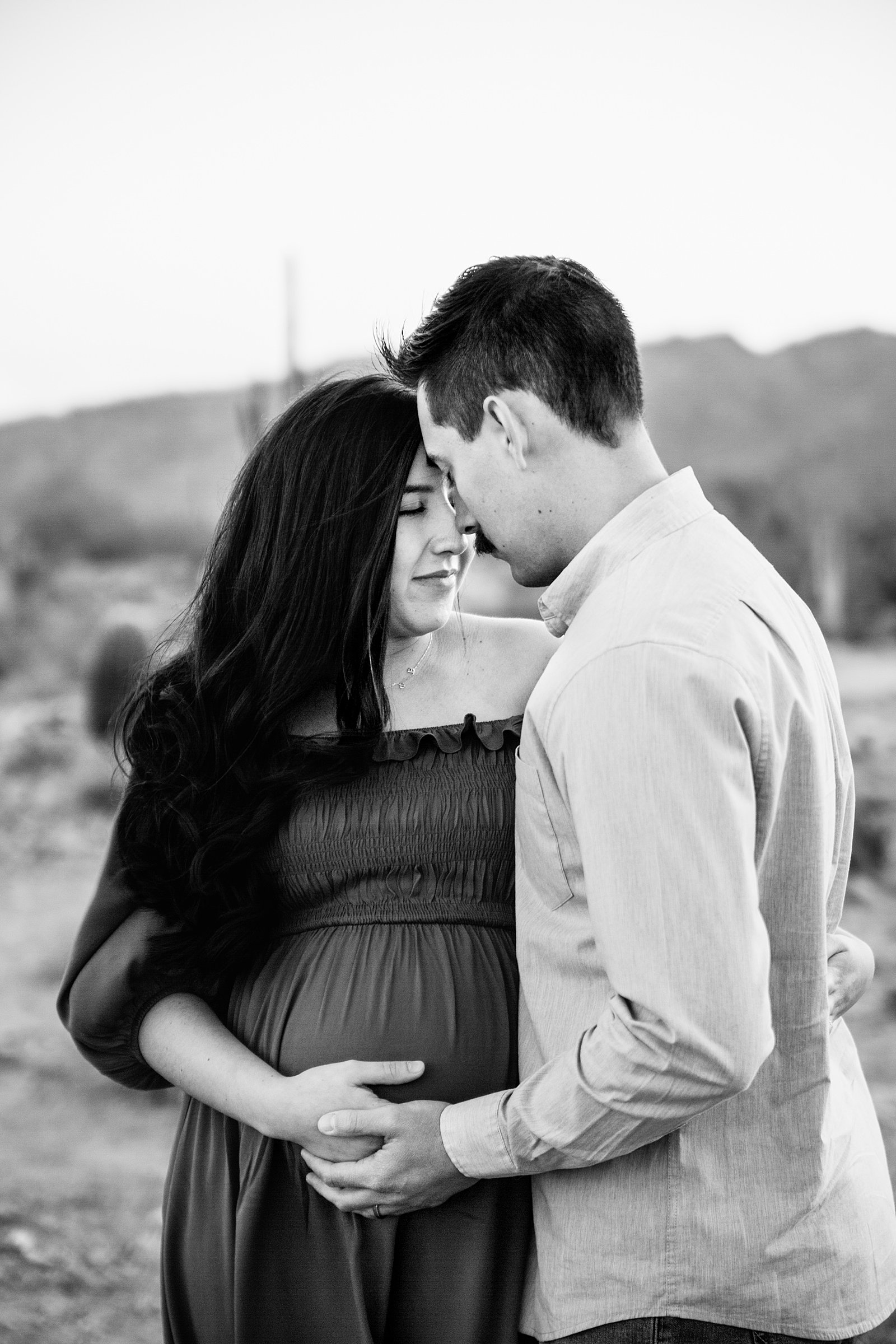 Couple share an intimate moment during their White Tanks maternity session by Phoenix engagement photographer PMA Photography.
