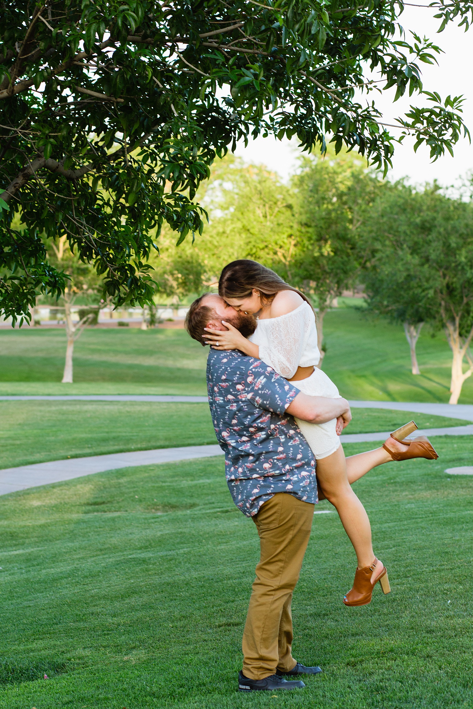 Couple share a kiss during their Anthem Park engagement session by Phoenix wedding photographer PMA Photography.