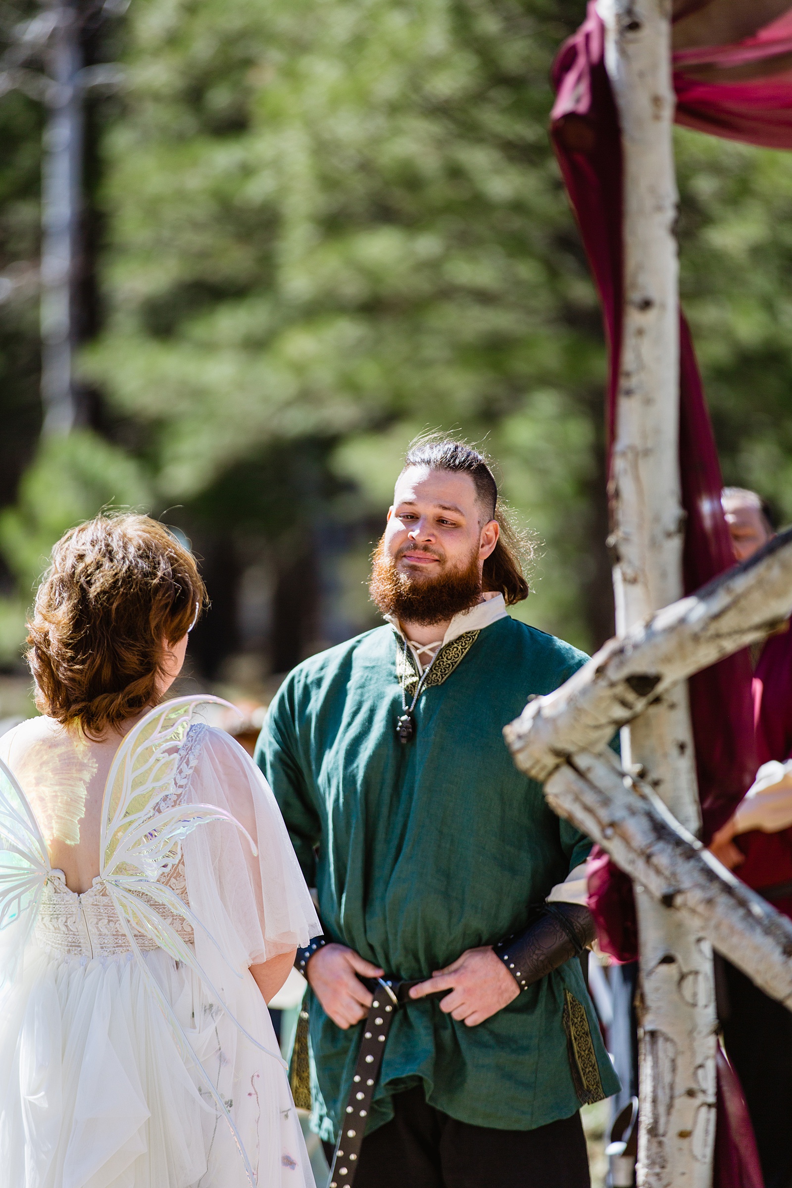 Groom looking at his bride during their wedding ceremony at Arizona Nordic Village by Flagstaff wedding photographer PMA Photography.