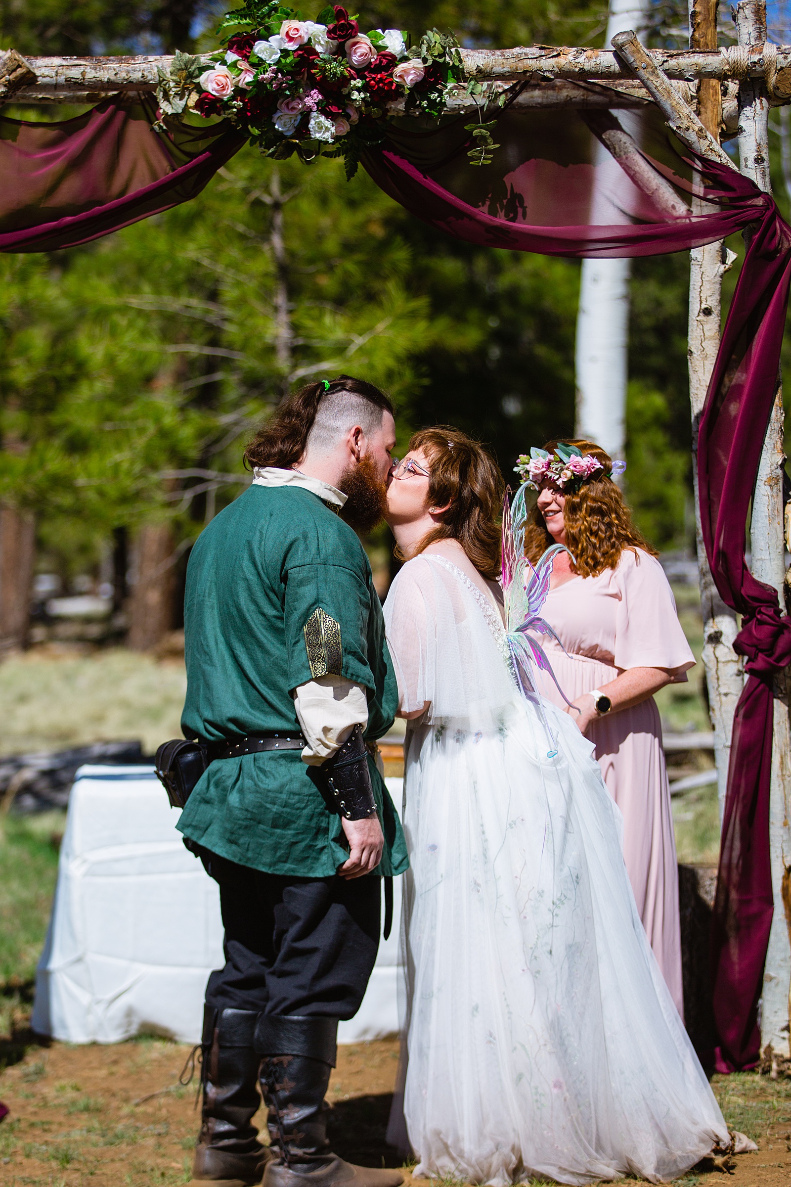 Bride and Groom share their first kiss during their wedding ceremony at Arizona Nordic Village by Arizona wedding photographer PMA Photography.