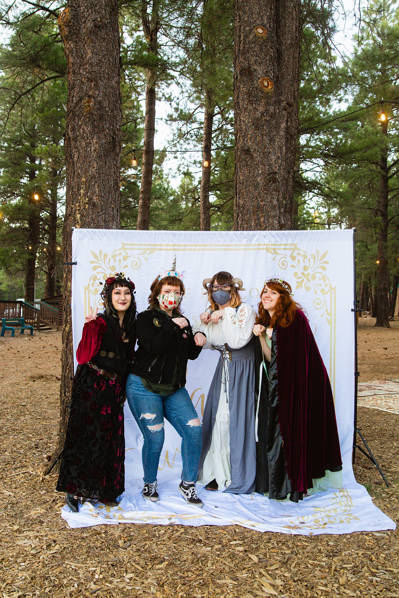 Bride poses with guests at a fairy tale inspired DIY photo booth by Arizona wedding photographer PMA Photography.