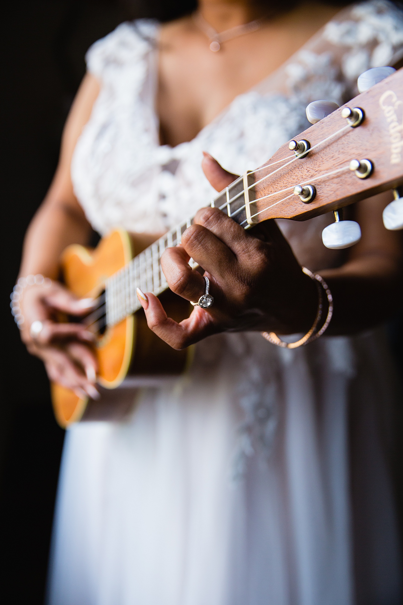 Bride playing a ukulele while getting ready for her wedding day by Arizona wedding photographer PMA Photography.