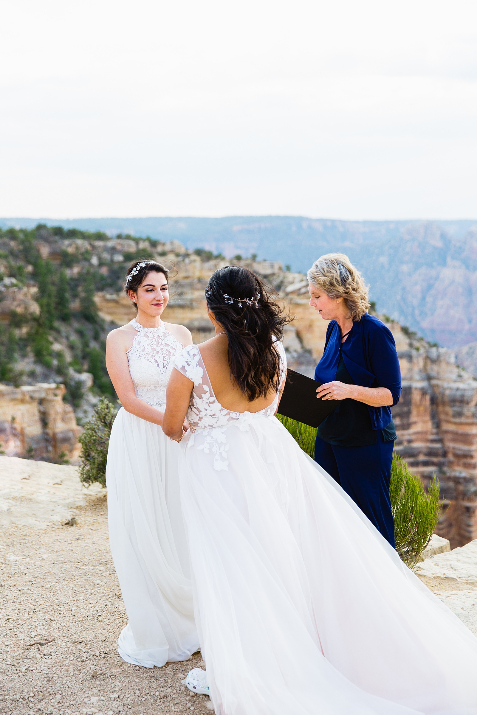 Brides looking at each other during their wedding ceremony at Moran Point by Grand Canyon elopement photographer PMA Photography.