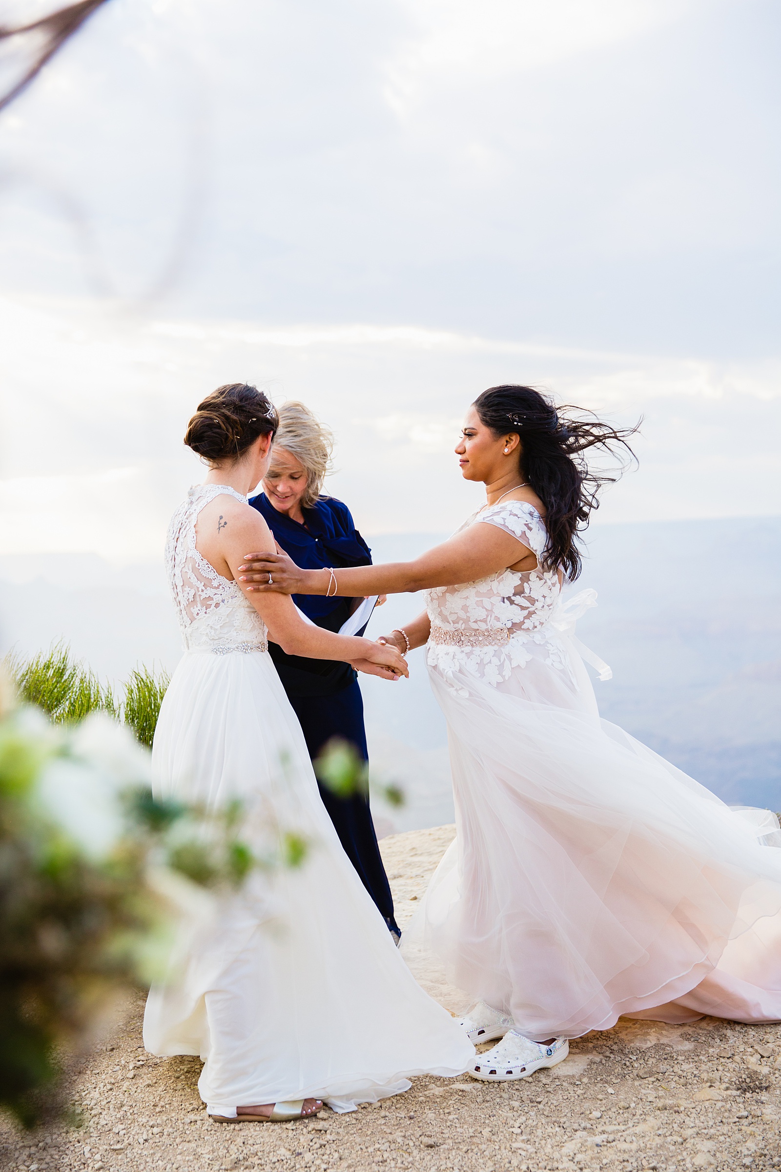 Brides share a moment during their wedding ceremony at their Grand Canyon elopement by PMA Photography.