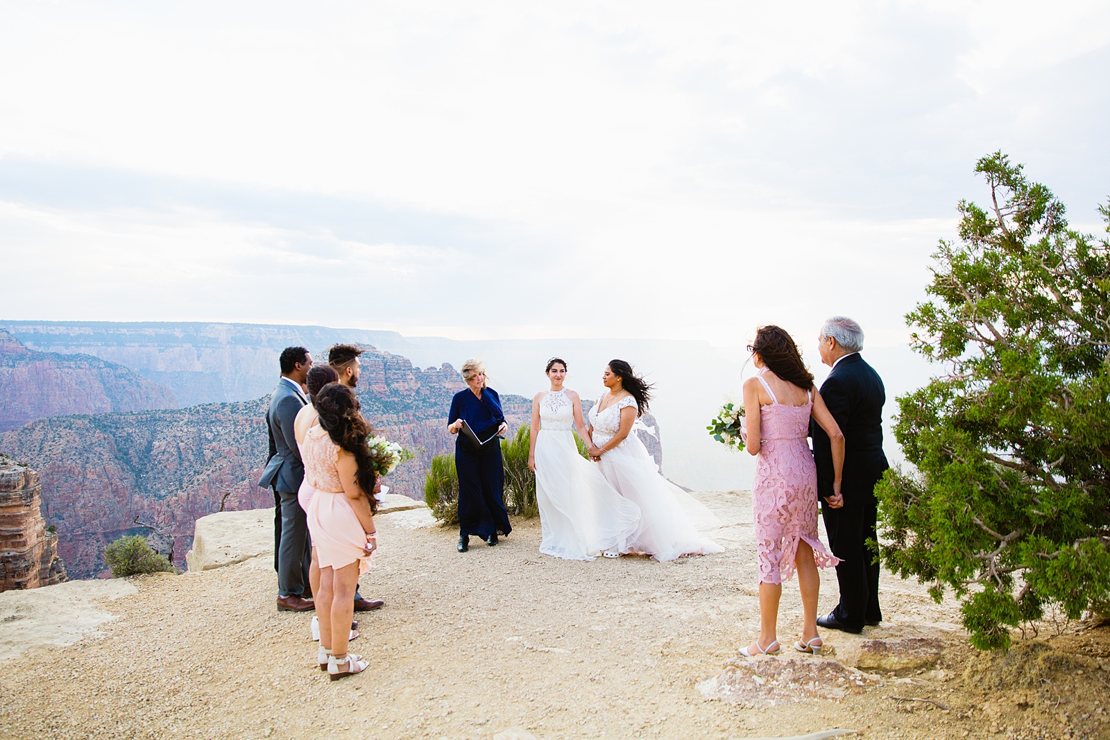 Brides looking at their guests during their wedding ceremony at their Grand Canyon elopement by PMA Photography.