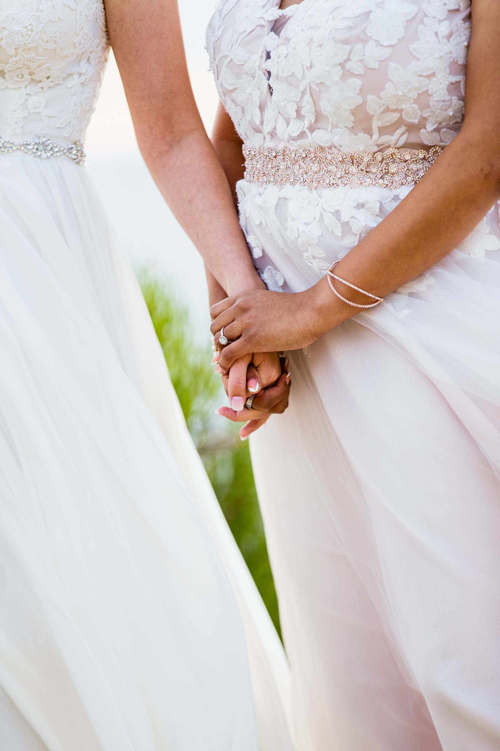 Brides holding hands during their wedding ceremony at their Grand Canyon elopement by PMA Photography.