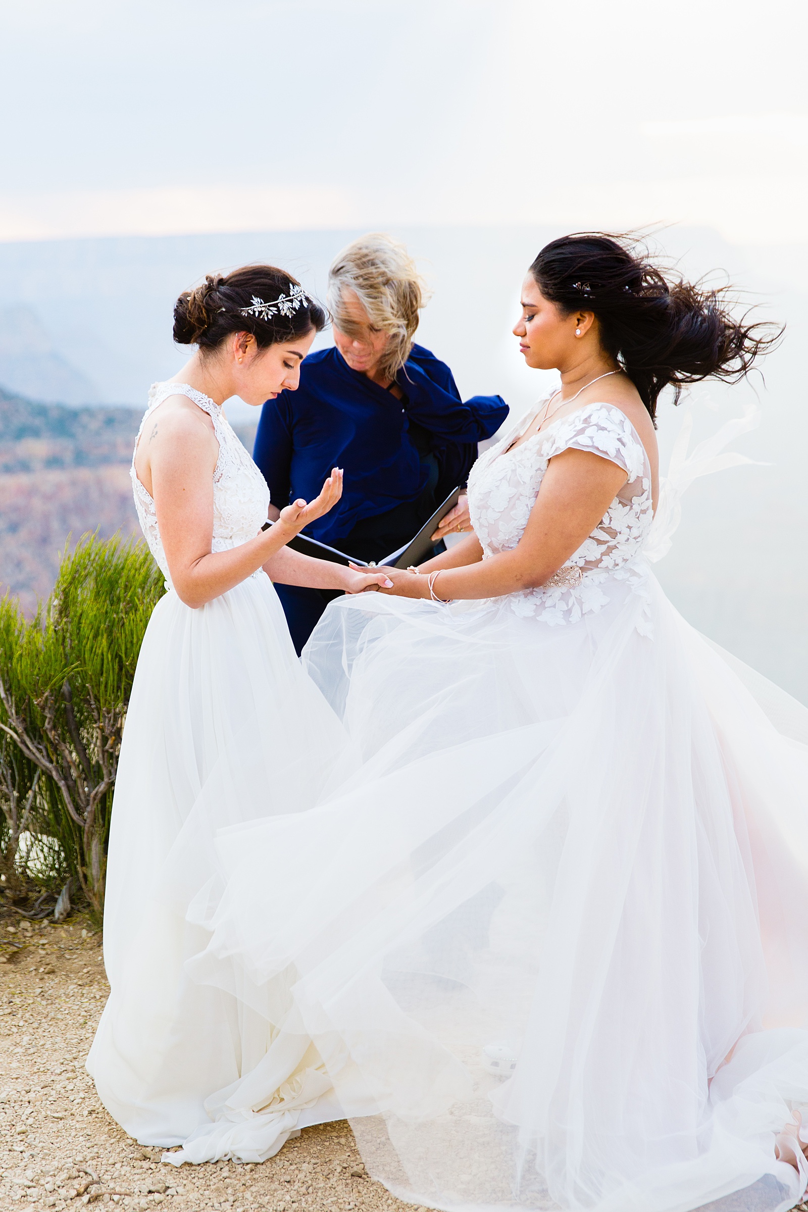 Lesbian couple praying together during their wedding ceremony by Grand Canyon Elopement Photographer PMA Photography.