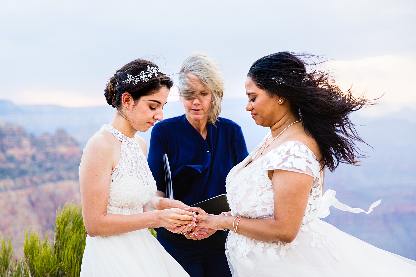Same sex couple exchange rings during their wedding ceremony at Moran Point by Arizona elopement photographer PMA Photography.