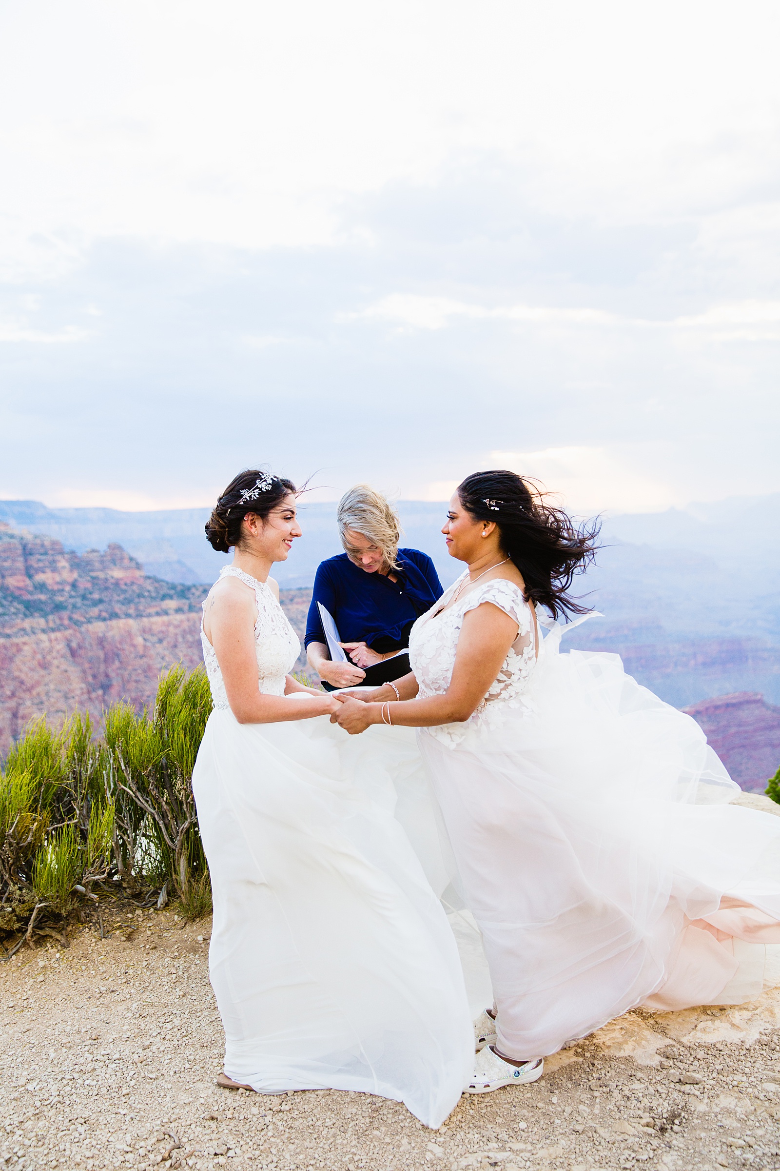 Same sex couple exchange rings during their wedding ceremony at Moran Point by Arizona elopement photographer PMA Photography.
