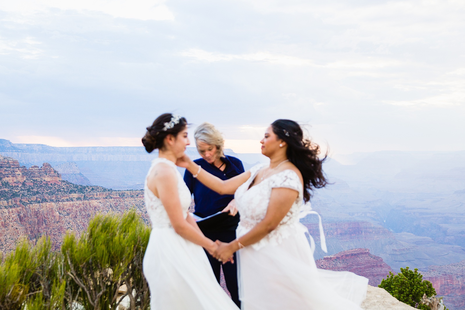 Brides share a moment during their wedding ceremony at their Grand Canyon elopement by PMA Photography.
